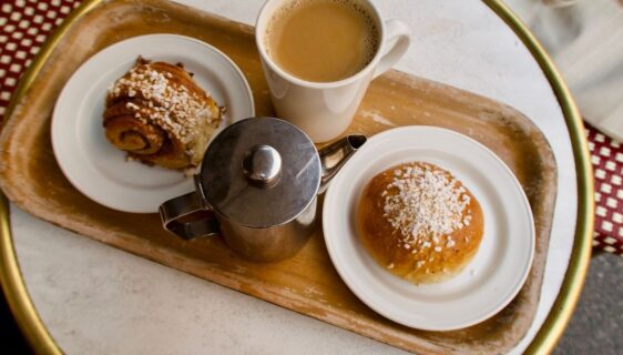 Fika med kaffe, kanelbullar och en silverfärgad kanna på bricka